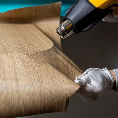 Installer heat-forming woodgrain architectural film around a panel edge