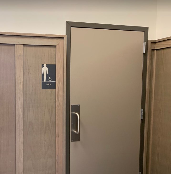 Restroom door and woodgrain wainscot paneling